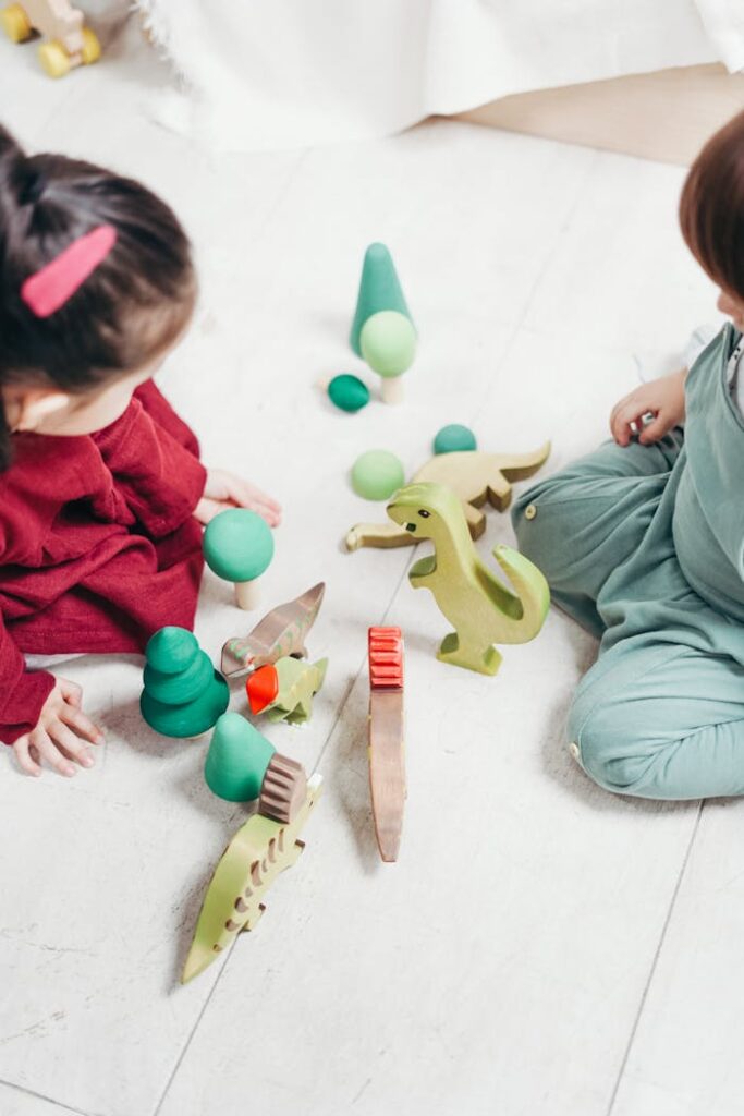 Two Children Sitting Down Playing with Toys